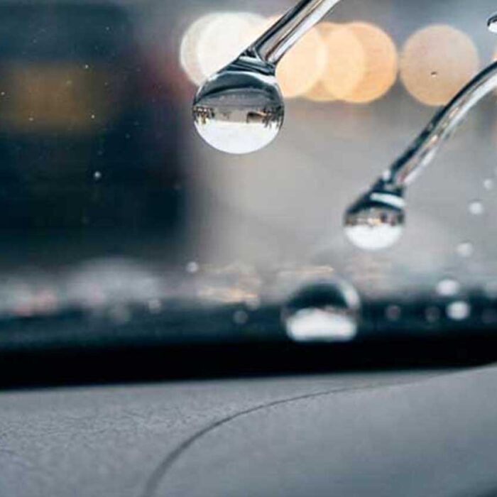 Wasser perlt von einer professionell versiegelten Autoscheibe ab und sorgt für bessere Sicht bei Regen in Braunschweig.